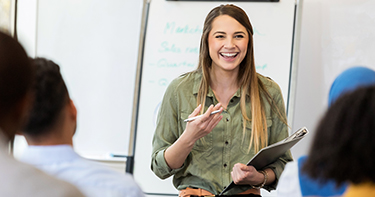 Woman laughing in front of class