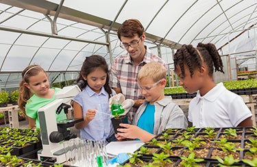 Teacher with students in greenhouse