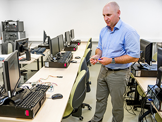 Man standing in front of computers in computer lab