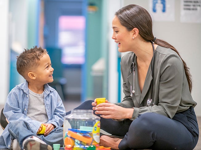 Doctor sitting with child on the floor