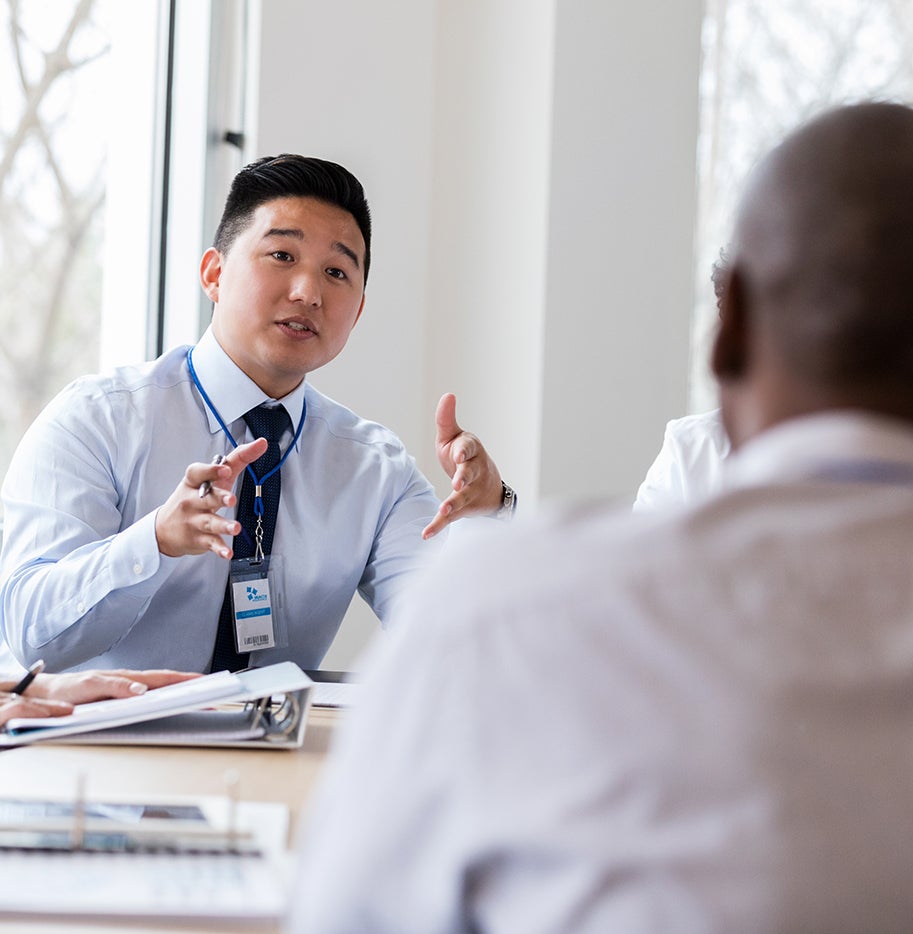 Man sitting at a table talking to a group