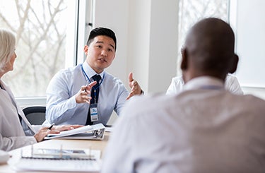 Man sitting at a table talking to a group