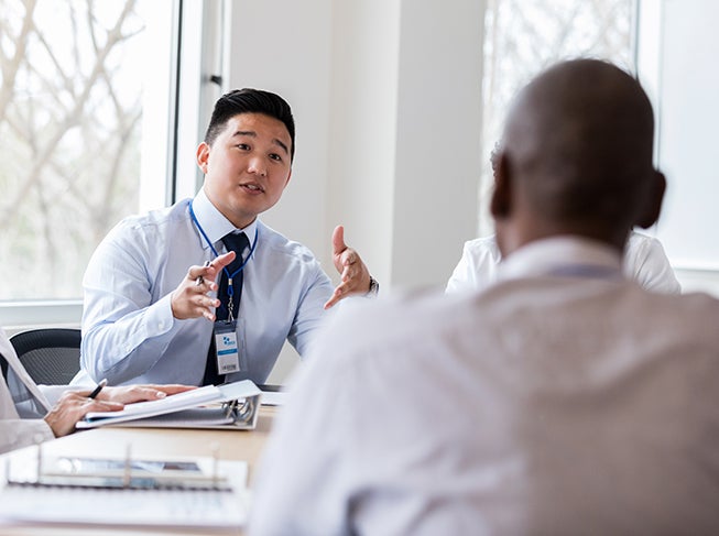 Man sitting at a table talking to a group