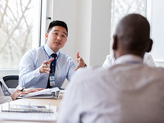 Man sitting at a table talking to a group