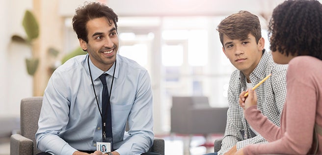 Man sitting talking to two students