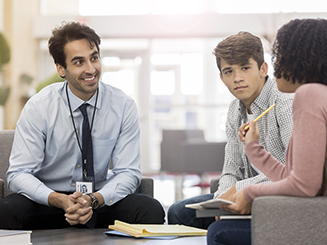 Man sitting talking to two students
