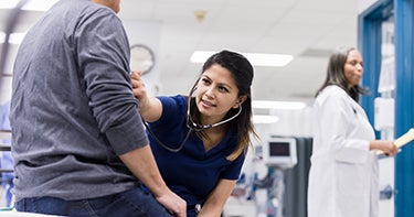 Nurse listening to heart of a patient