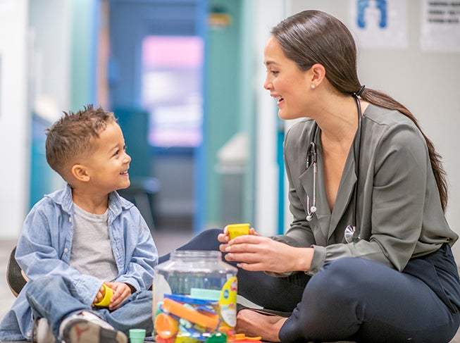 Doctor sitting with child on the floor