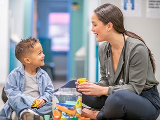 Doctor sitting with child on the floor