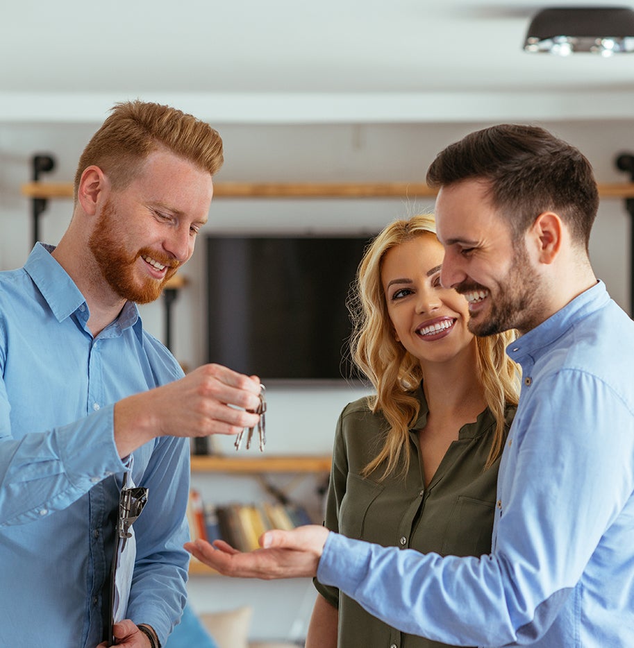 Real estate agent handing over keys to couple