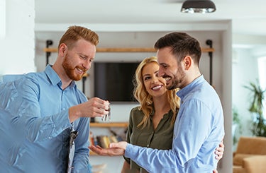 Real estate agent handing over keys to couple