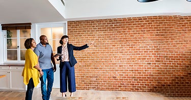 Real estate agent showing off house to couple