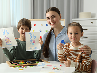 Teacher working on alphabet with a female and male student.