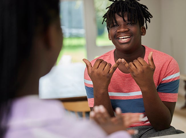 Student working with teacher working on sign language.