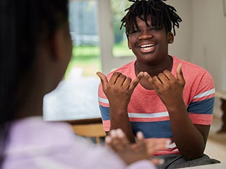 Student working with teacher working on sign language.