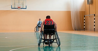 Child in wheelchair on a basketball court.