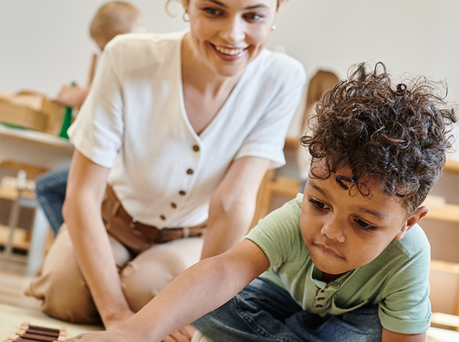 Child playing with train tracks on the floor